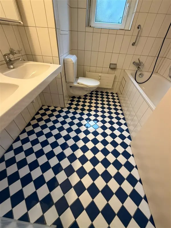 Sauberes Badezimmer mit blau-weiss kariertem Plattenboden