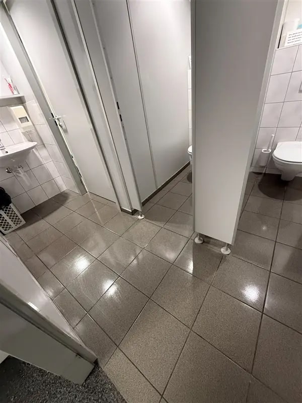 Sanitärgang mit glänzend gereinigtem Plattenboden